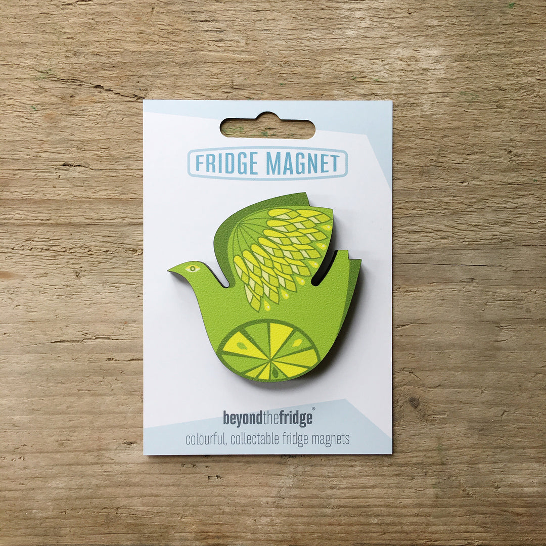 A retro citrus bird lemon and lime design plywood fridge magnet by Beyond the Fridge in it’s pack on a wooden background