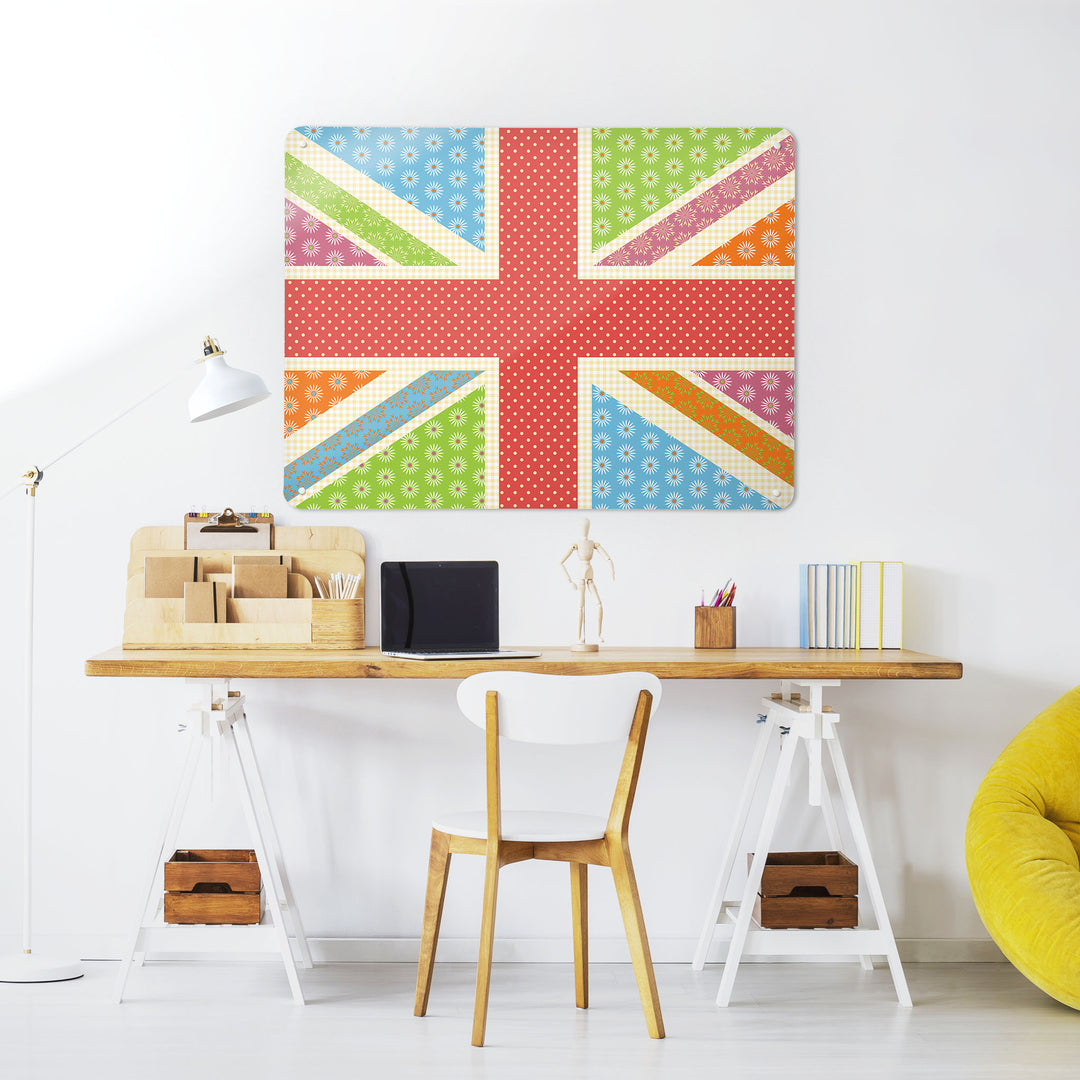 A desk in a workspace setting in a white interior with a magnetic metal wall art panel showing a Cool Britannia design in fruity colours