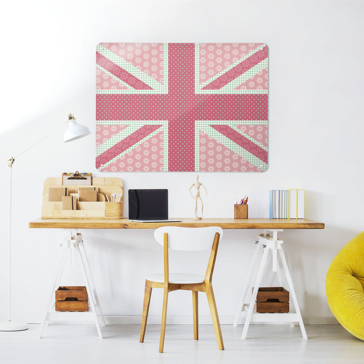 A desk in a workspace setting in a white interior with a magnetic metal wall art panel showing a Cool Britannia design in pink and green