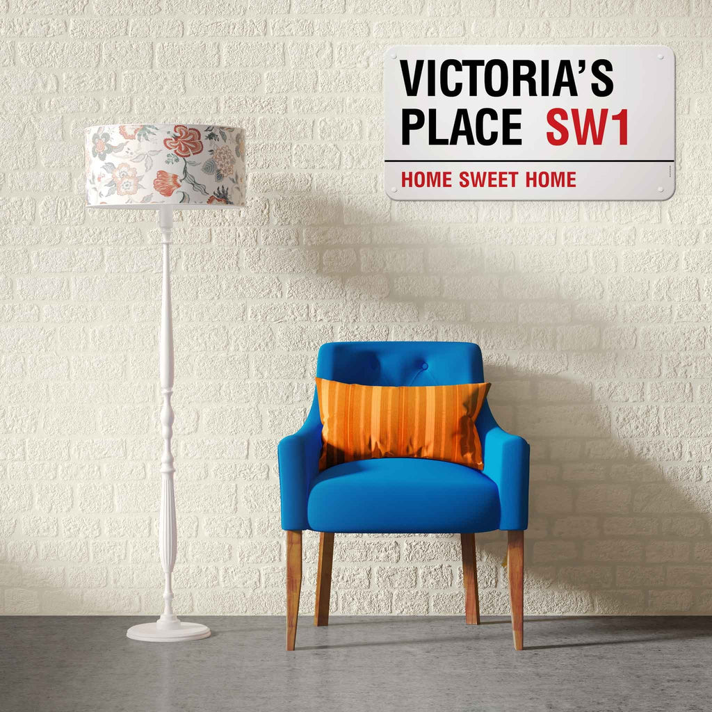 A personalised London street sign reading Victoria’s Place SW1 above a blue armchair