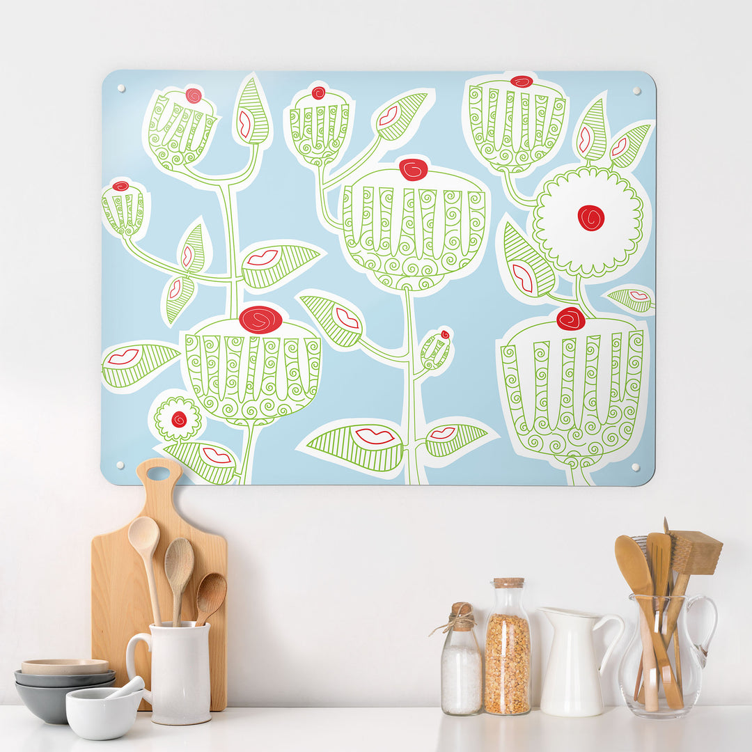 A kitchen interior with a magnetic metal wall art panel showing a cupcake plant design in green, red, white and blue
