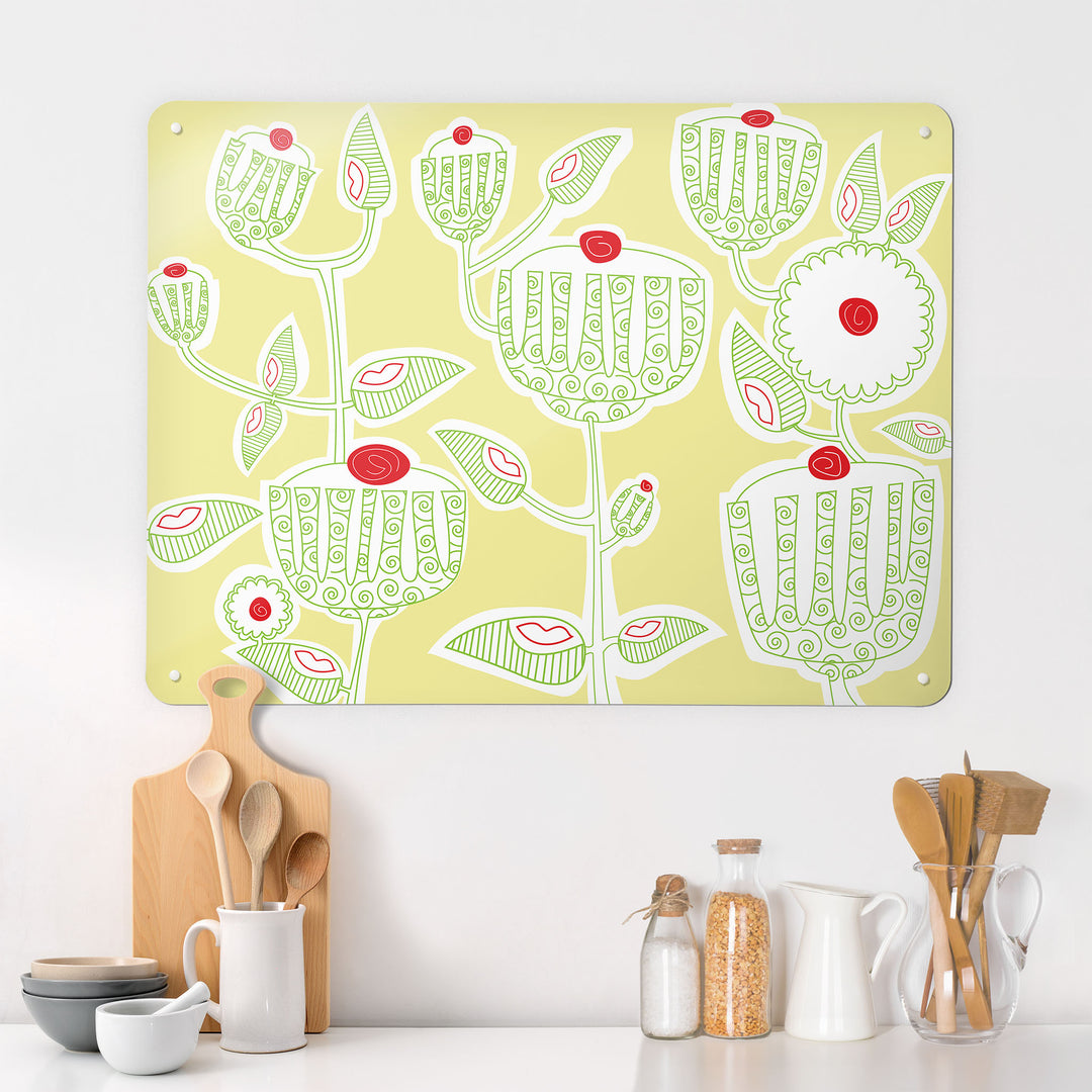 A kitchen interior with a magnetic metal wall art panel showing a cupcake plant design in green, red, white and yellow