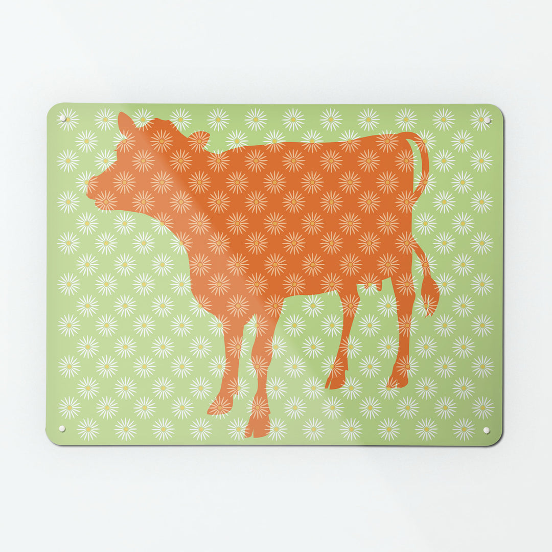 A large magnetic notice board by Beyond the Fridge with a daisy the cow design in orange, white and green