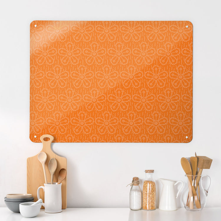 A kitchen interior with a magnetic metal wall art panel showing a fizzy flower design in orangeade colour