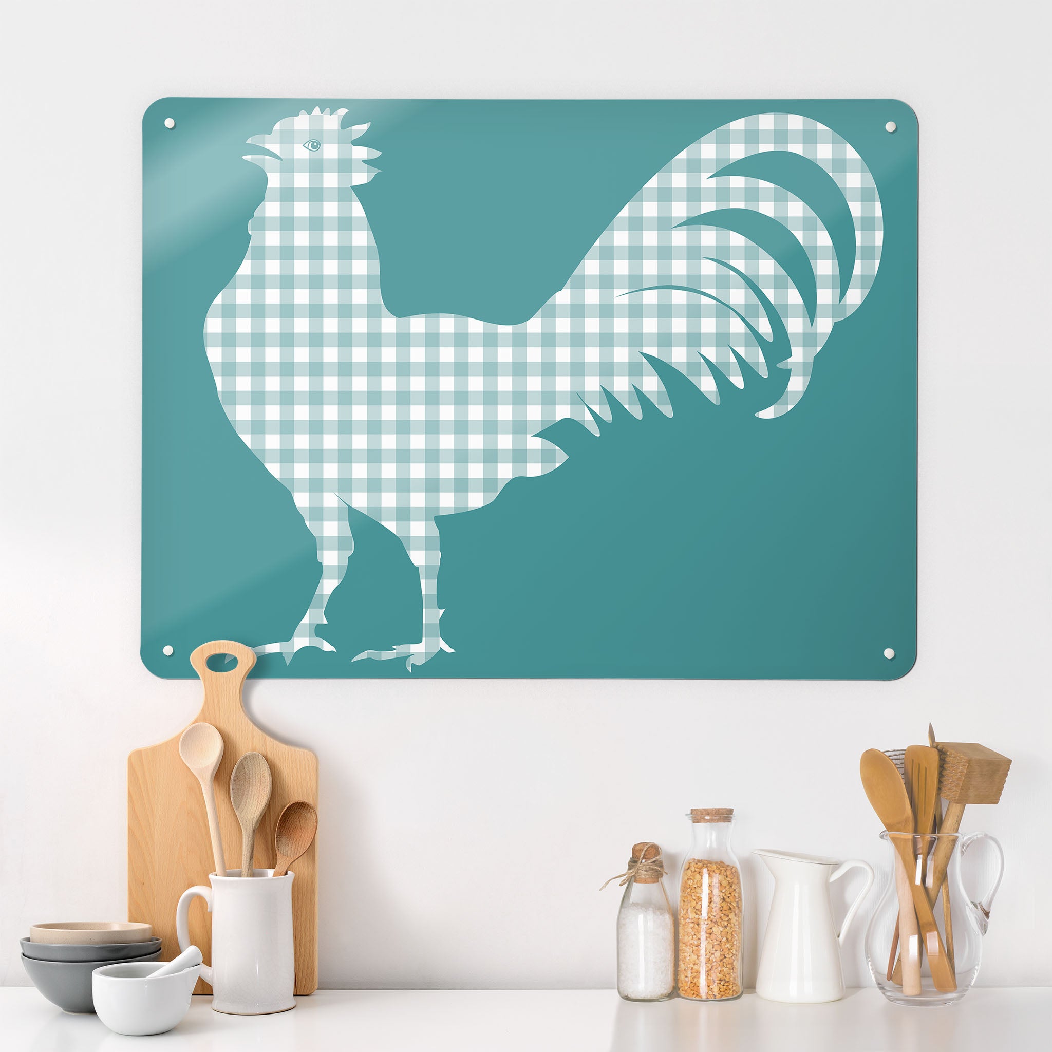 A kitchen interior with a magnetic metal wall art panel with a blue gingham cockerel design