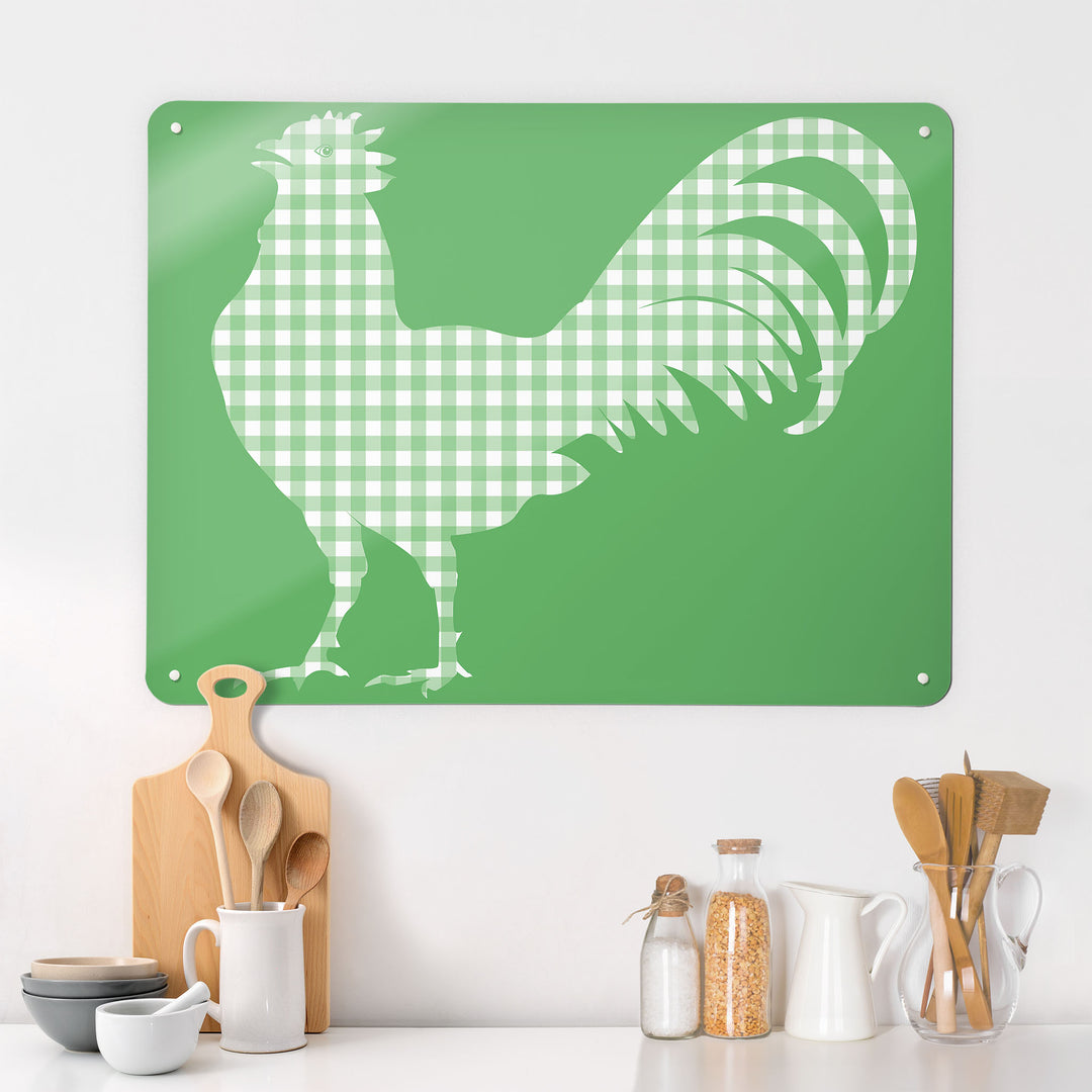 A kitchen interior with a magnetic metal wall art panel with a green gingham cockerel design