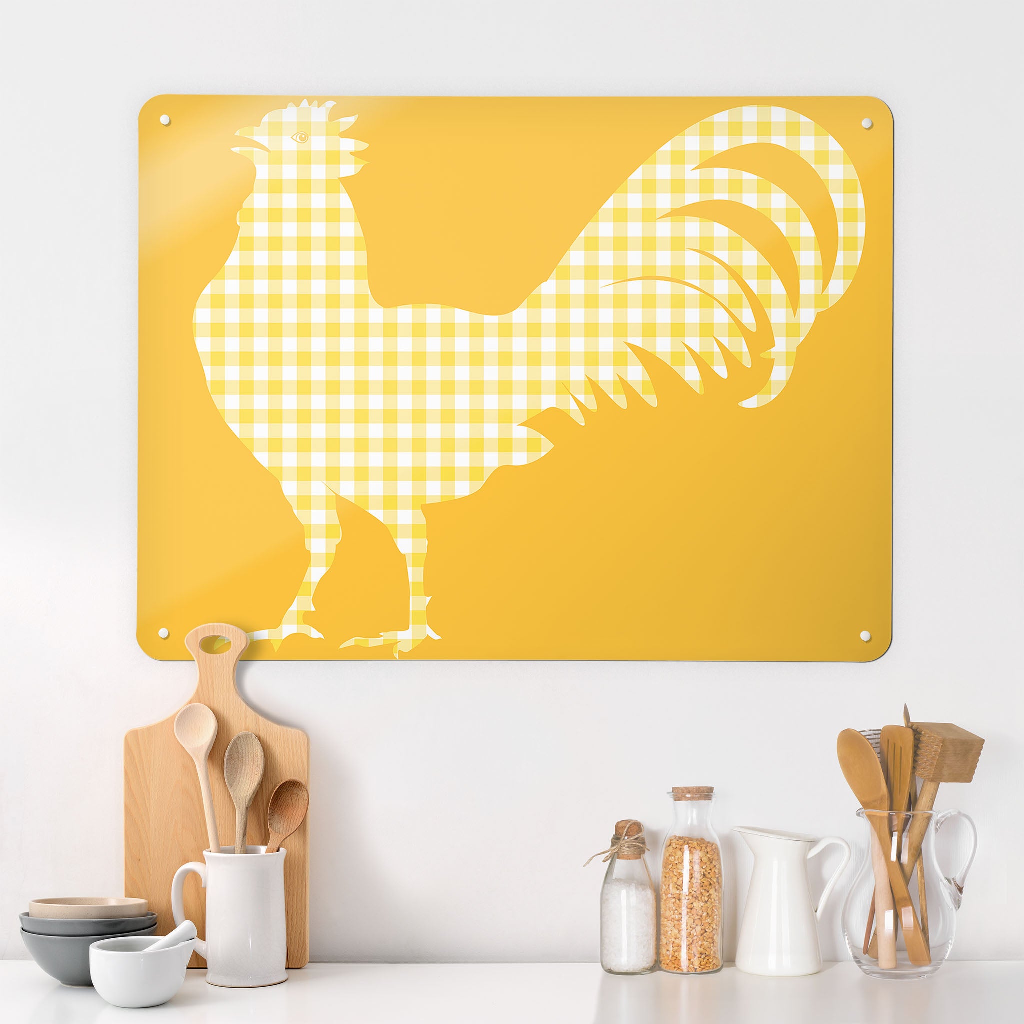 A kitchen interior with a magnetic metal wall art panel with a yellow gingham cockerel design