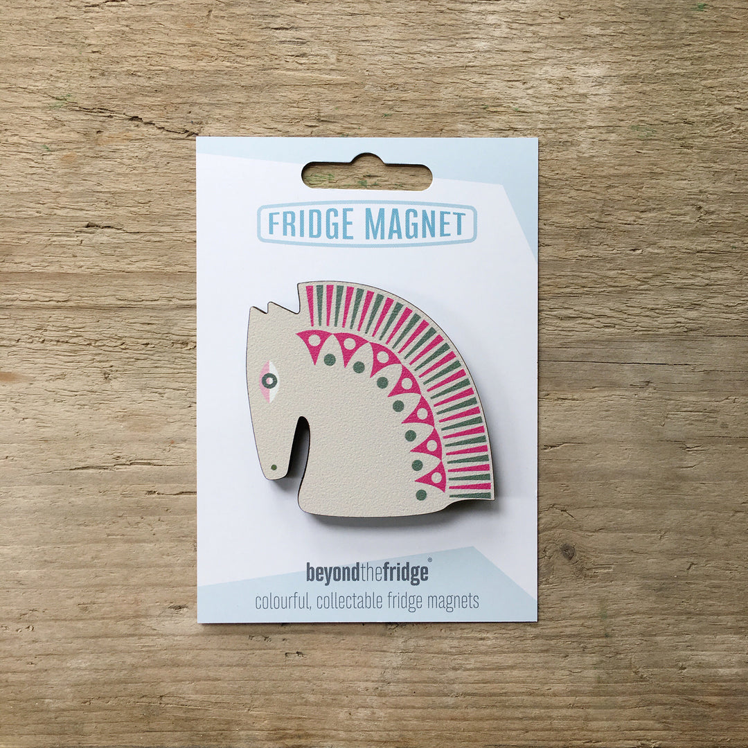 A grey horse head design plywood fridge magnet by Beyond the Fridge in it’s pack on a wooden background