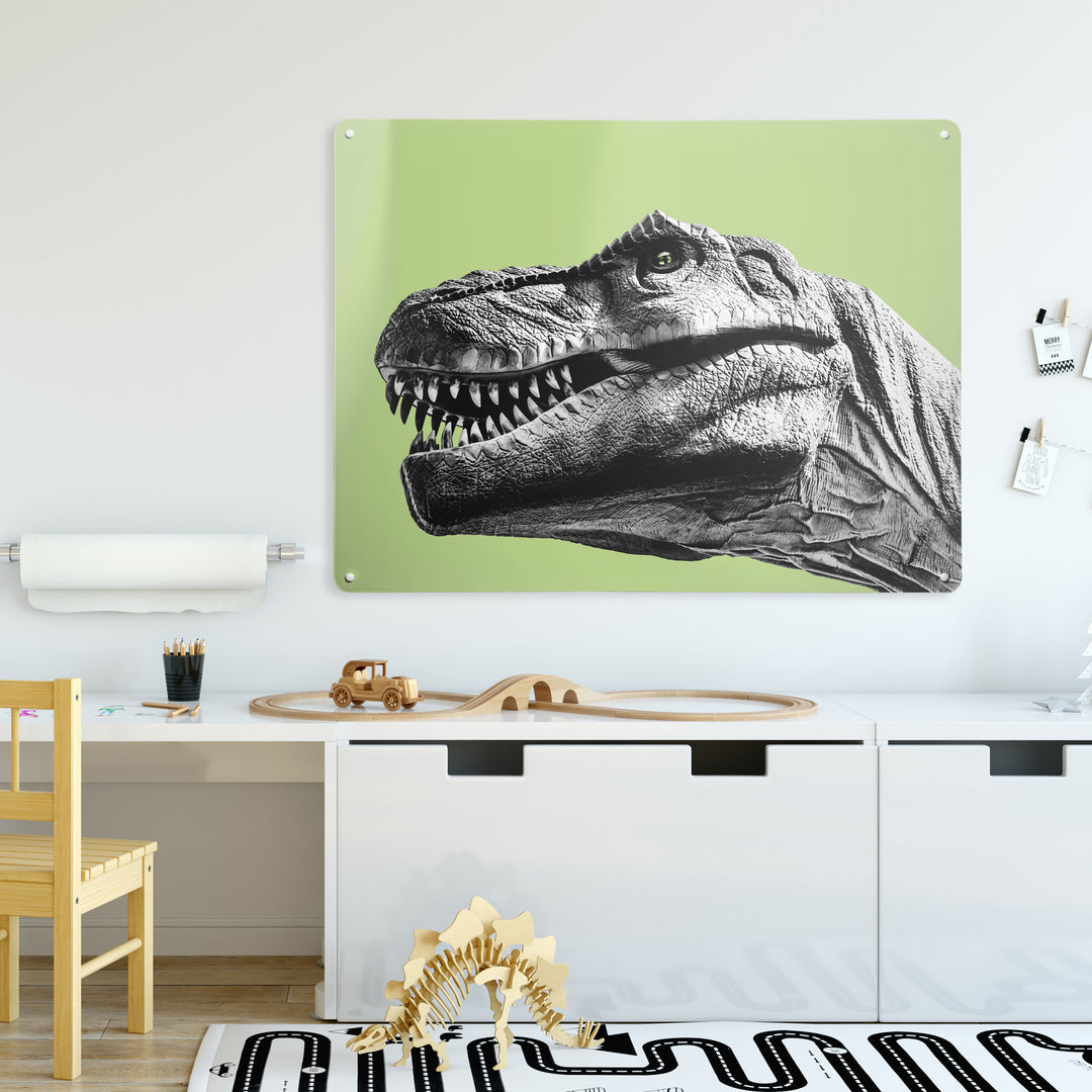 A desk  in a white kid's room interior with a magnetic metal wall art panel showing a black and white tyrannosaurus rex dinosaur on a green background