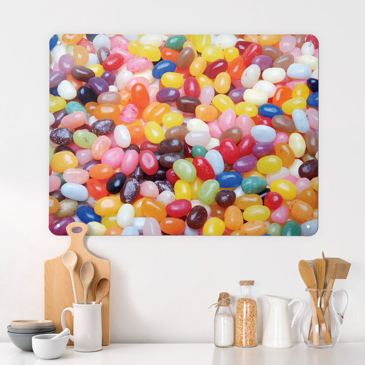 A desk in a kitchen interior with a magnetic metal wall art panel showing a photograph of colourful jelly beans