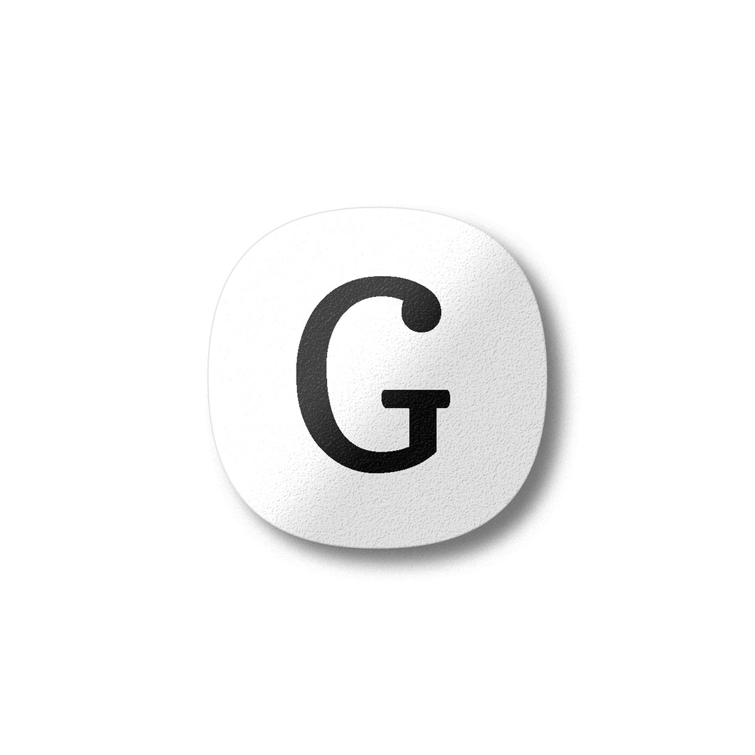 A white magnet with a black letter G plywood fridge magnet by Beyond the Fridge
