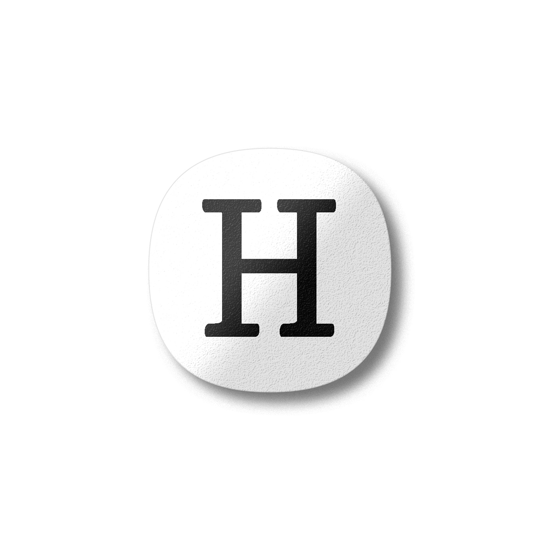 A white magnet with a black letter H plywood fridge magnet by Beyond the Fridge
