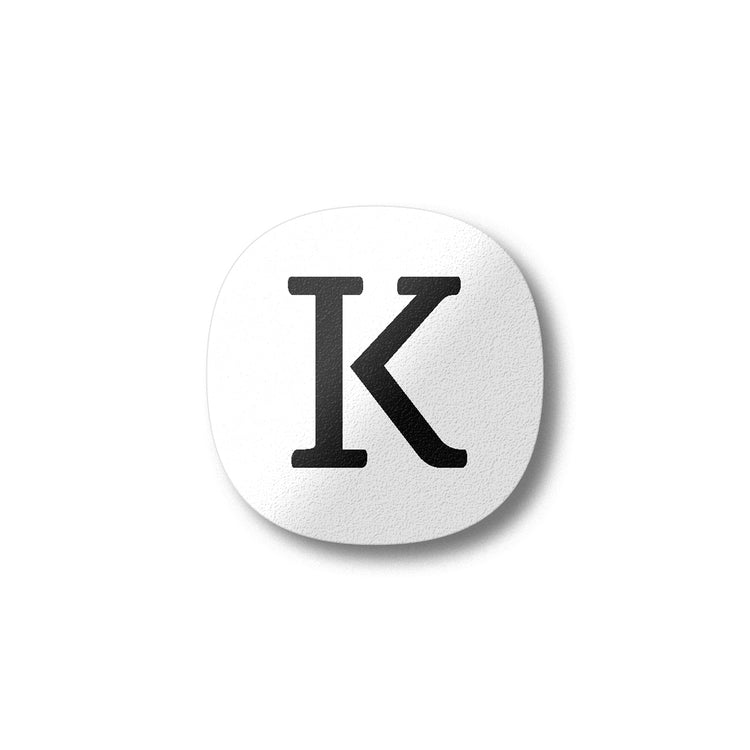 A white magnet with a black letter K plywood fridge magnet by Beyond the Fridge