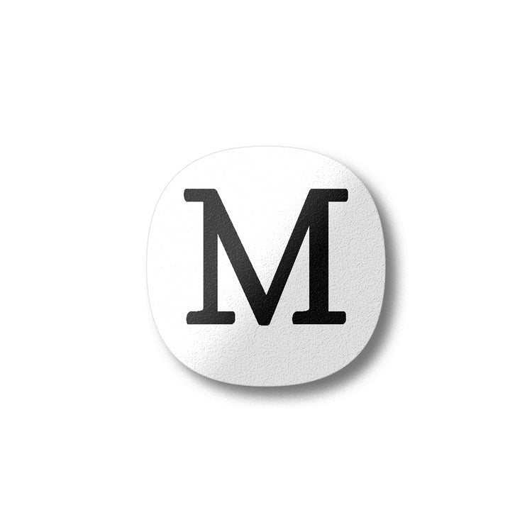 A white magnet with a black letter M plywood fridge magnet by Beyond the Fridge