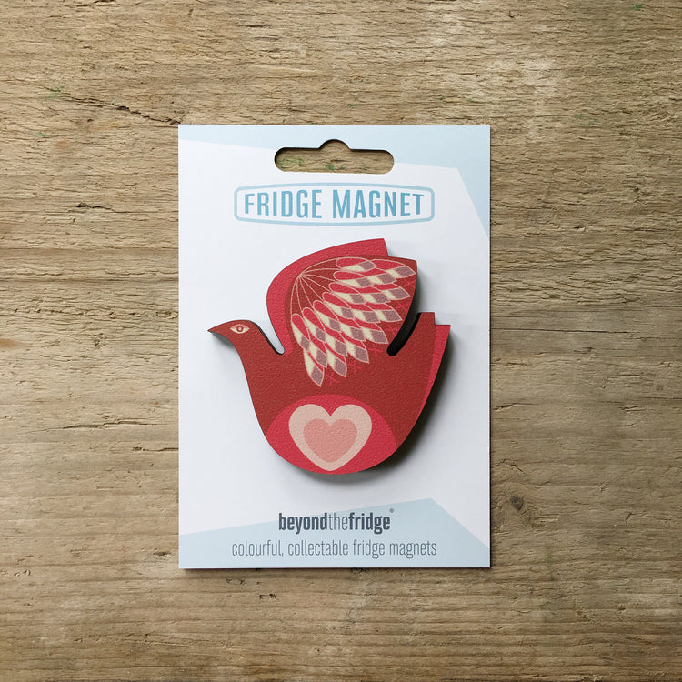 A retro love bird design plywood fridge magnet by Beyond the Fridge in it’s pack on a wooden background