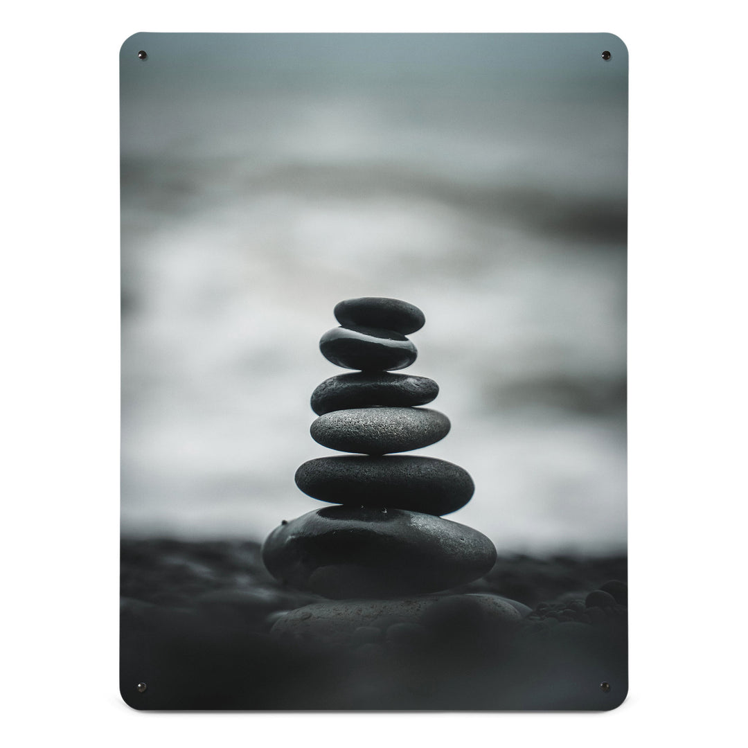 A large magnetic notice board by Beyond the Fridge with a monochrome photograph of balancing stones on a beach