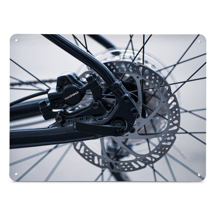 A large magnetic notice board by Beyond the Fridge with a black and white photograph of bicycle spokes