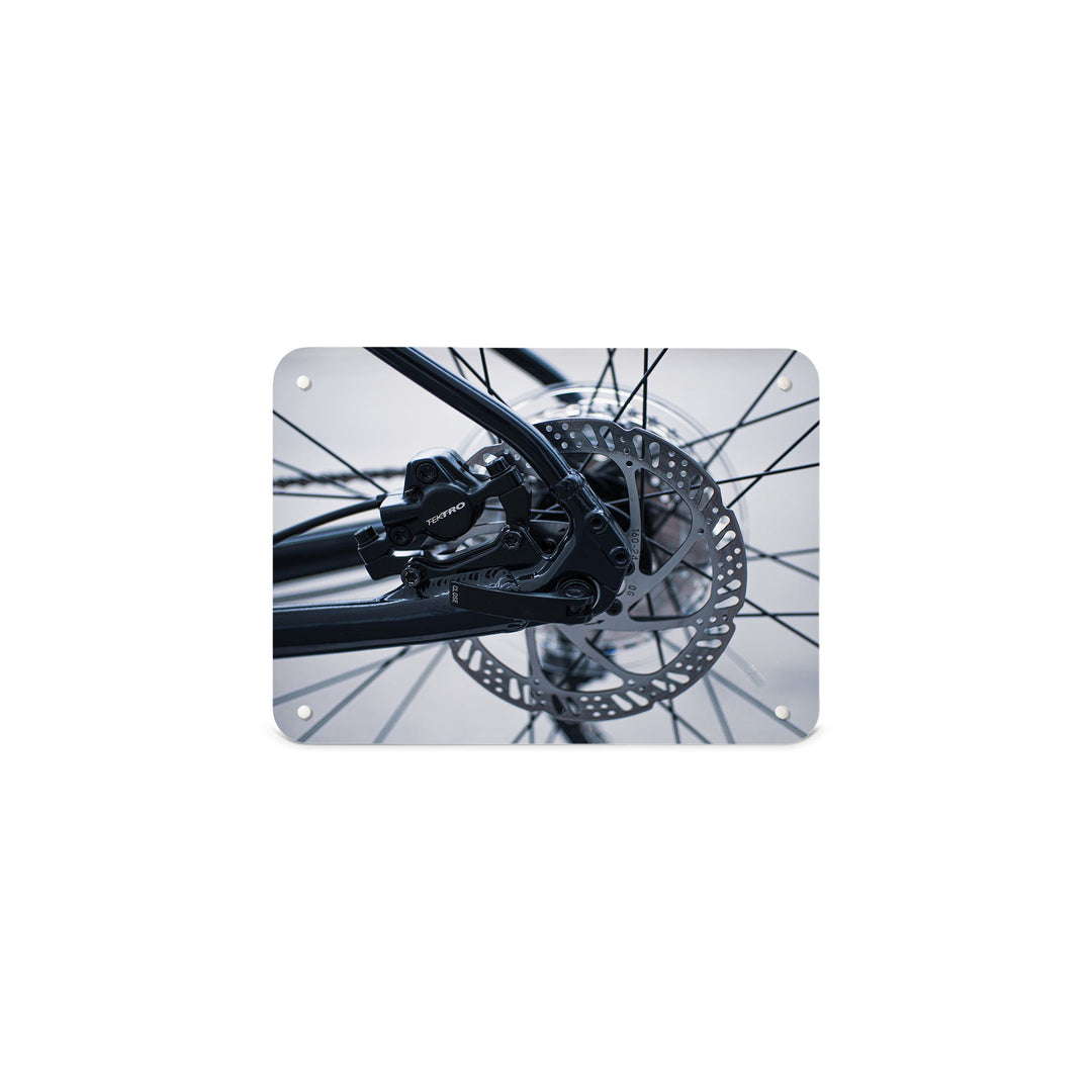 A small magnetic notice board by Beyond the Fridge with a black and white photograph of bicycle spokes