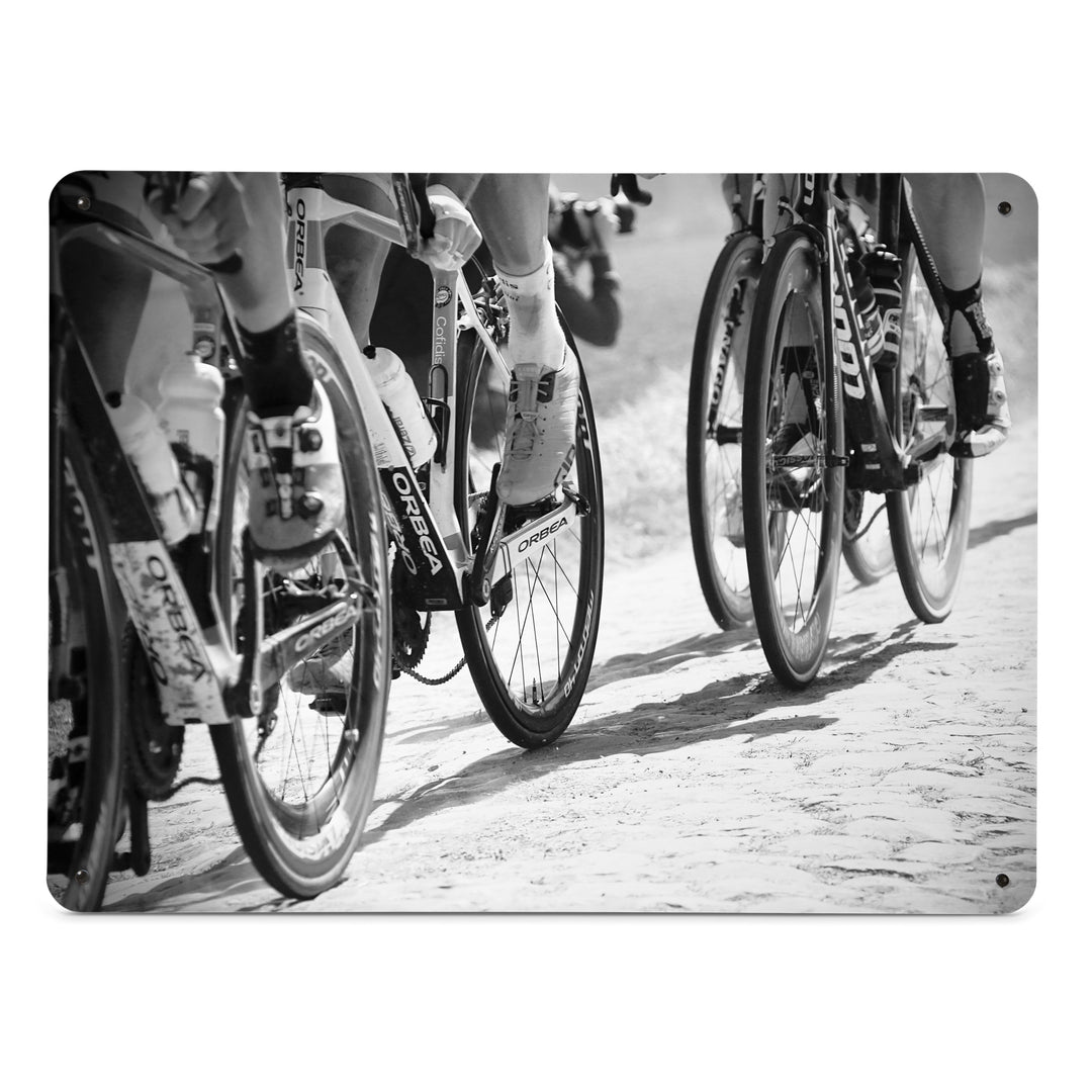 A large magnetic notice board by Beyond the Fridge with a black and white image of cyclists focusing on the wheels of the bikes