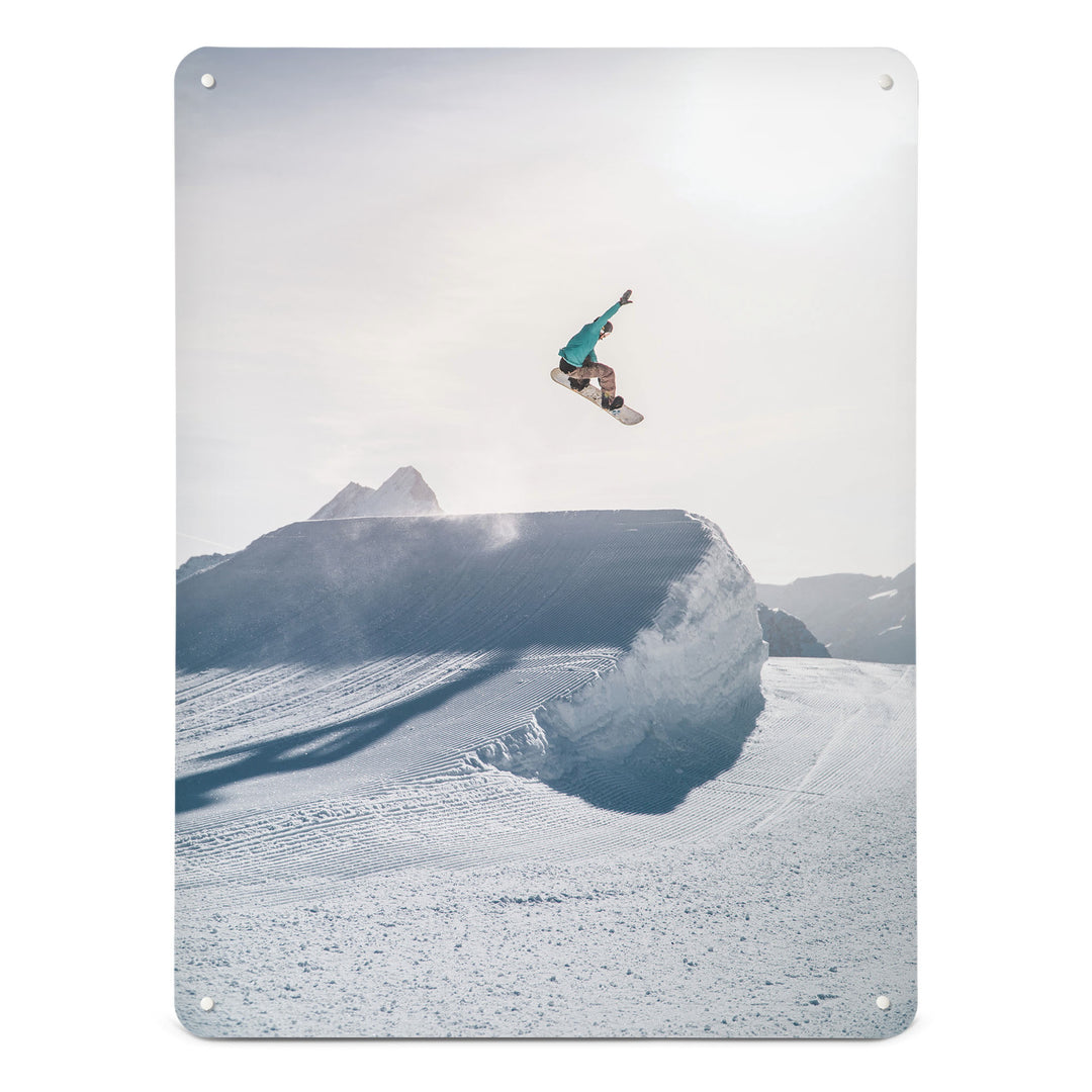 A large magnetic notice board by Beyond the Fridge with a photograph of a snowboarder jumping on a snowboard in a bright snowy landscape
