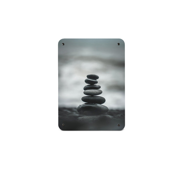 A small magnetic notice board by Beyond the Fridge with a monochrome photograph of balancing stones on a beach