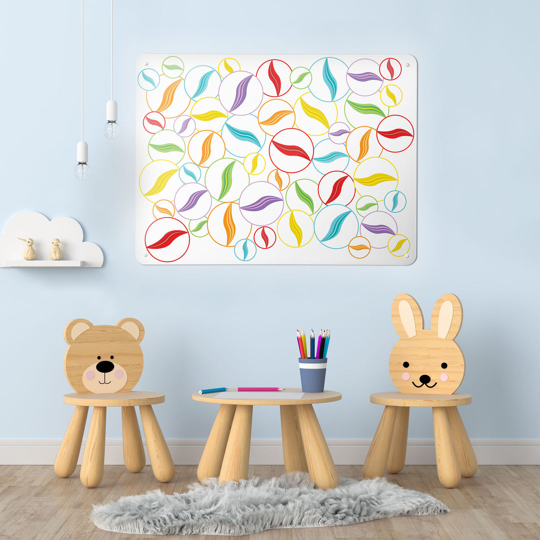 A playroom interior with a magnetic metal wall art panel showing multi coloured marbles on a white background design