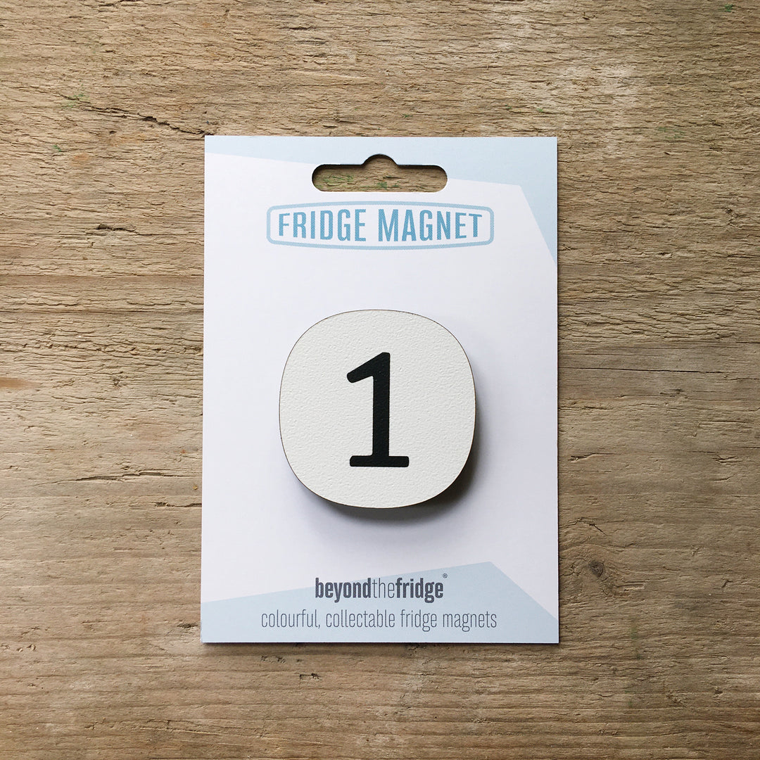 A number 1 design plywood fridge magnet by Beyond the Fridge in it’s pack on a wooden background