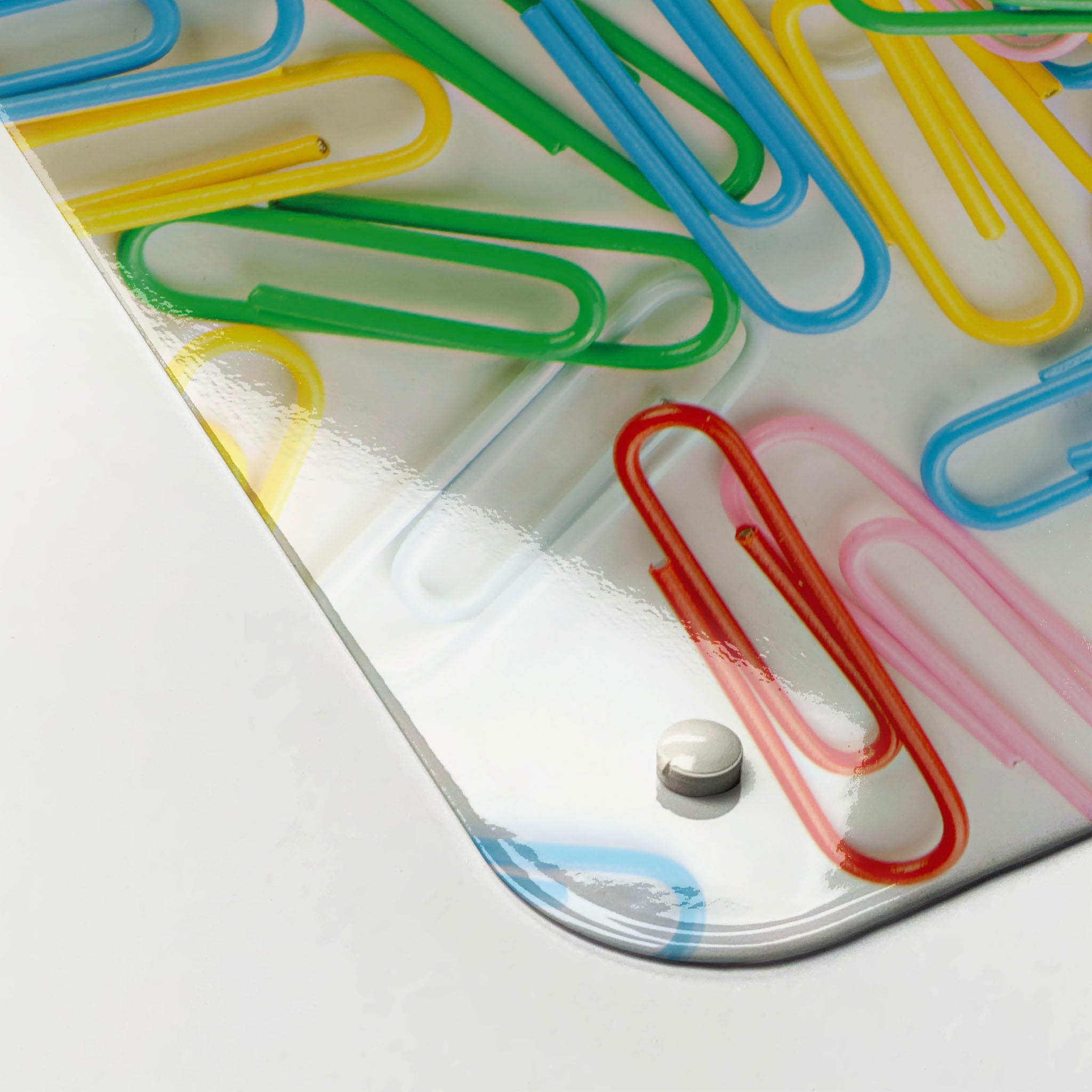 The corner detail of a paper clips photographic magnetic board to show it’s high gloss surface