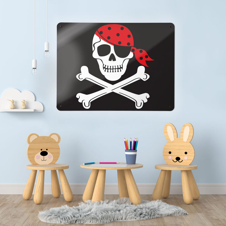 A desk in a workspace setting in a white interior with a magnetic metal wall art panel with a Pirate flag design
