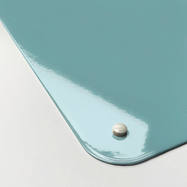 The corner detail of a plain blue magnetic board to show it’s high gloss surface
