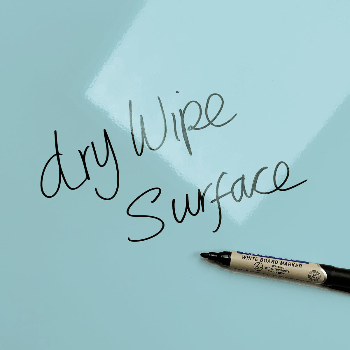 The words dry wipe surface written in marker pen on the Plain Blue magnetic notice board
