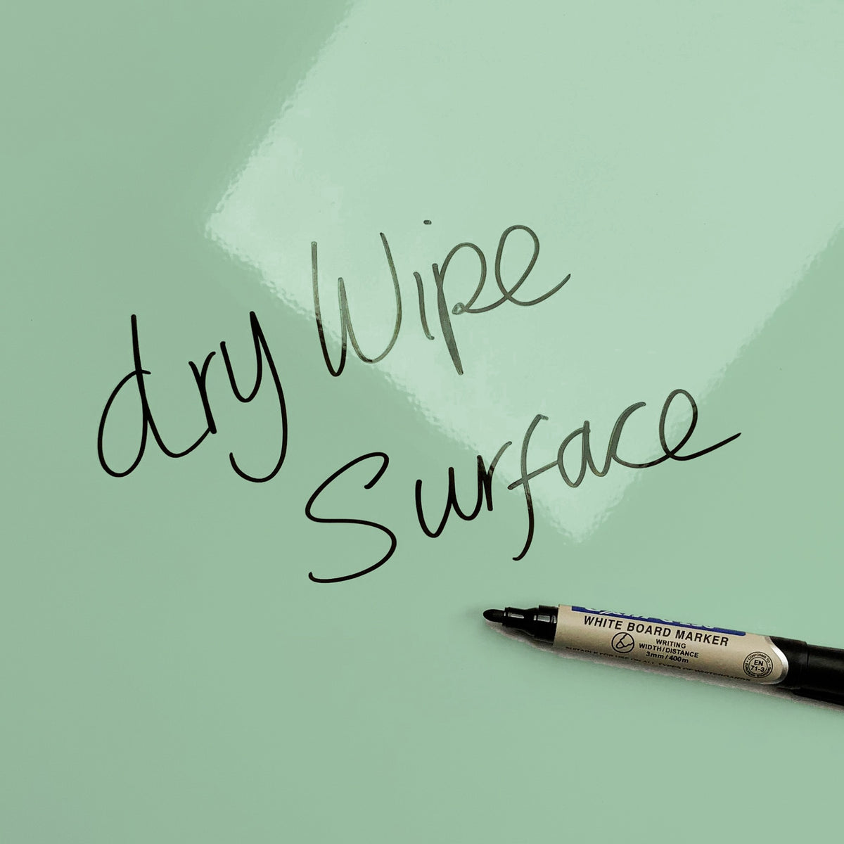 The words dry wipe surface written in marker pen on the Plain Green magnetic notice board