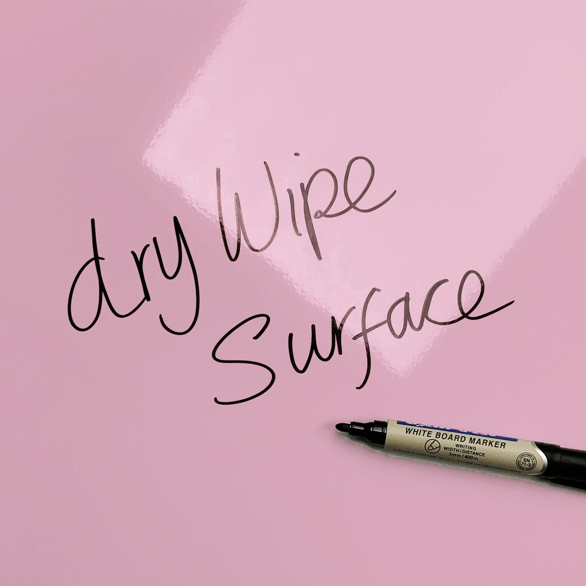 The words dry wipe surface written in marker pen on the Plain Pink magnetic notice board