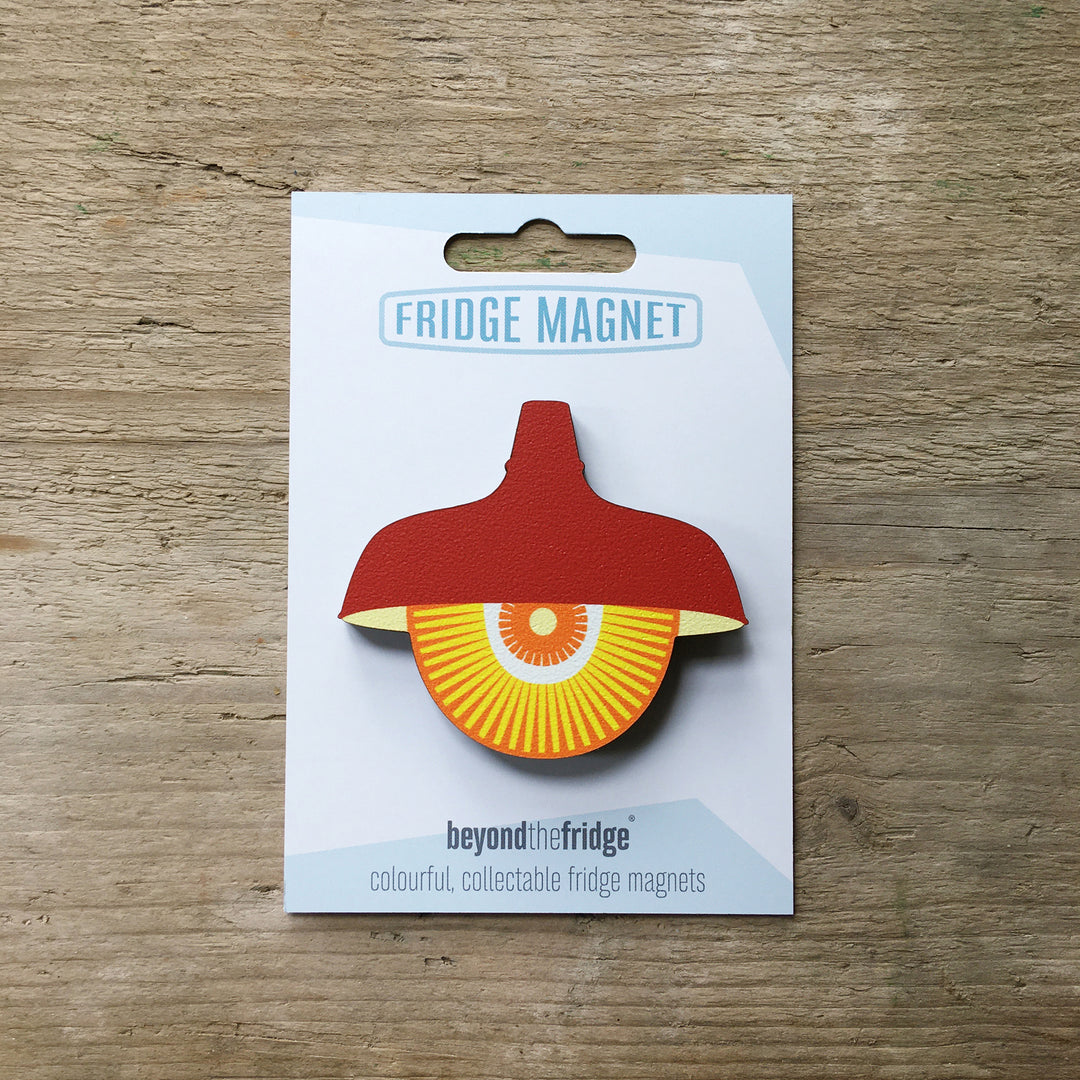 A red retro pendant light design plywood fridge magnet by Beyond the Fridge in it’s pack on a wooden background