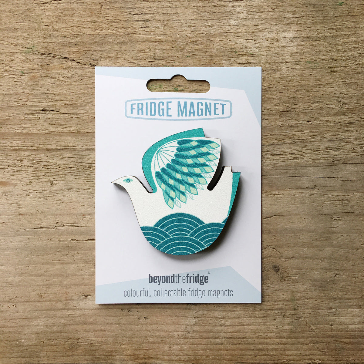 A retro seabird design plywood fridge magnet by Beyond the Fridge in it’s pack on a wooden background
