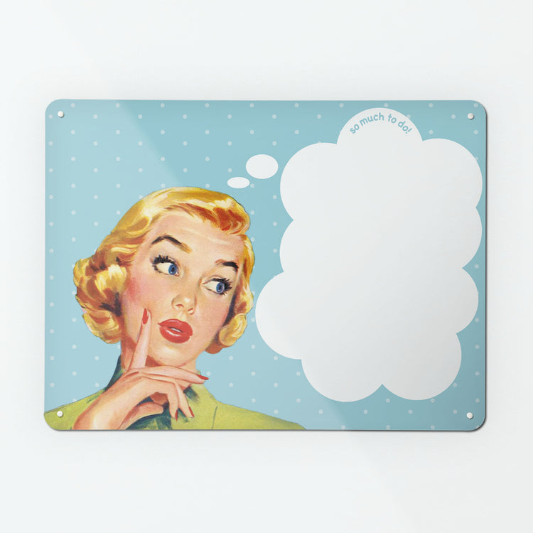 A large dry wipe magnetic notice board by Beyond the Fridge with a vintage girl illustration on blue polkadot background and white though bubble with 'so much to do' message