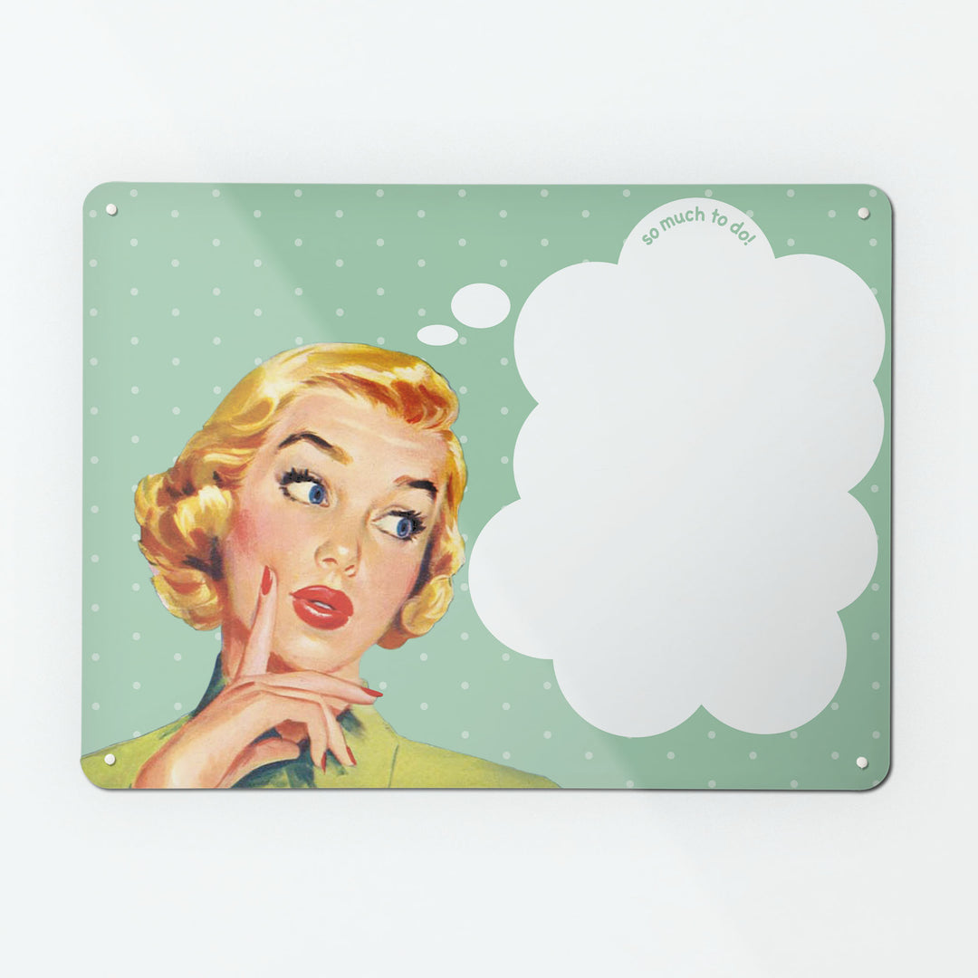 A large dry wipe magnetic notice board by Beyond the Fridge with a vintage girl illustration on green polkadot background and white though bubble with 'so much to do' message