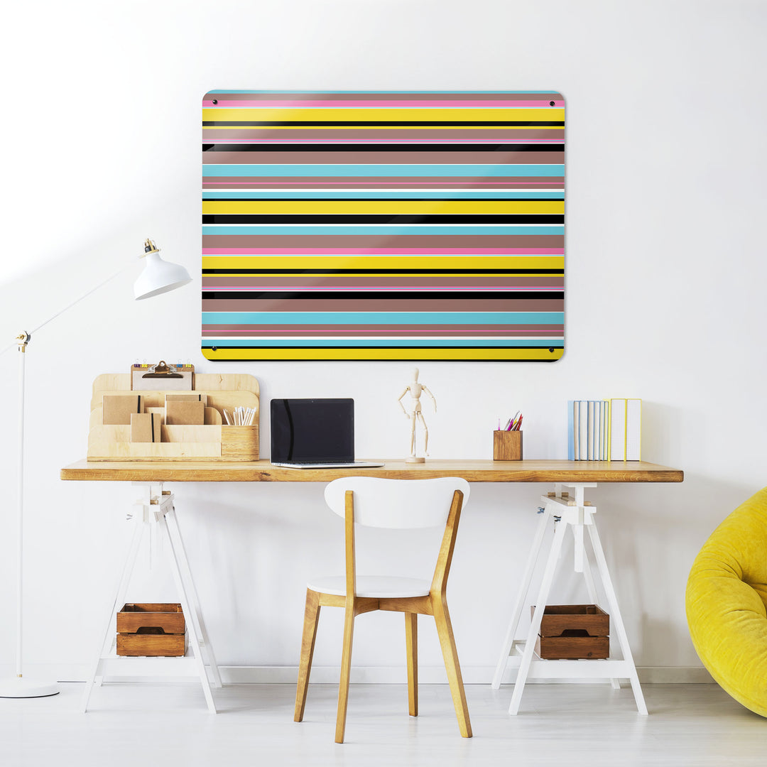 A desk in a workspace setting in a white interior with a magnetic metal wall art panel showing a stripes design in  liquorice colours