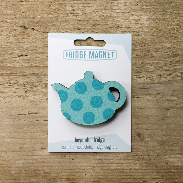 A aqua spotty teapot design plywood fridge magnet by Beyond the Fridge in it’s pack on a wooden background