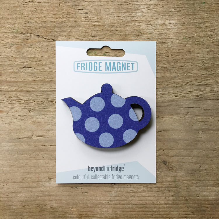 A blue spotty teapot design plywood fridge magnet by Beyond the Fridge in it’s pack on a wooden background