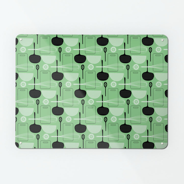 A large magnetic notice board by Beyond the Fridge with a utensils repeat pattern design in green colour way
