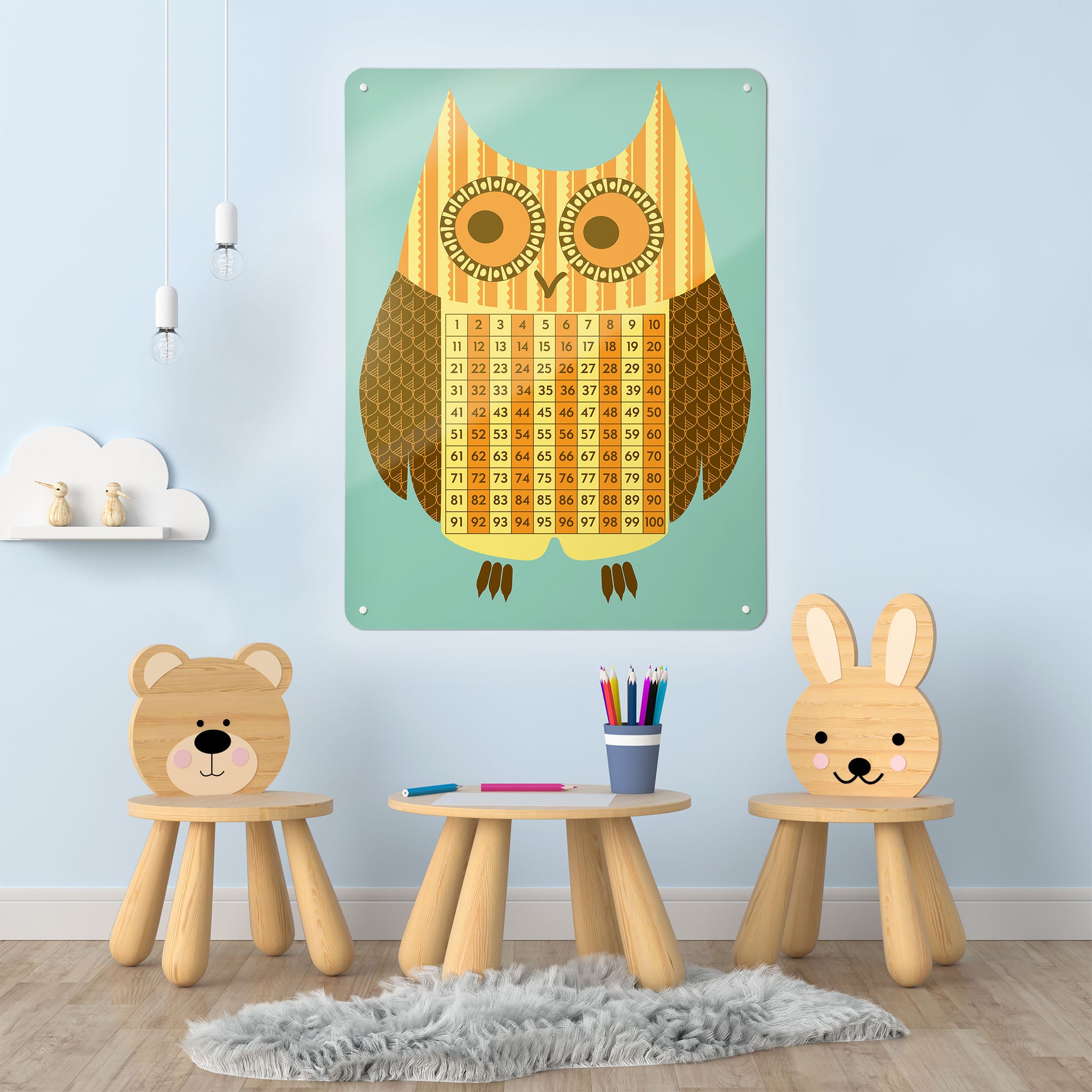 A playroom interior with a magnetic metal wall art panel showing an illustration of an owl with a number square design in blue and yellow