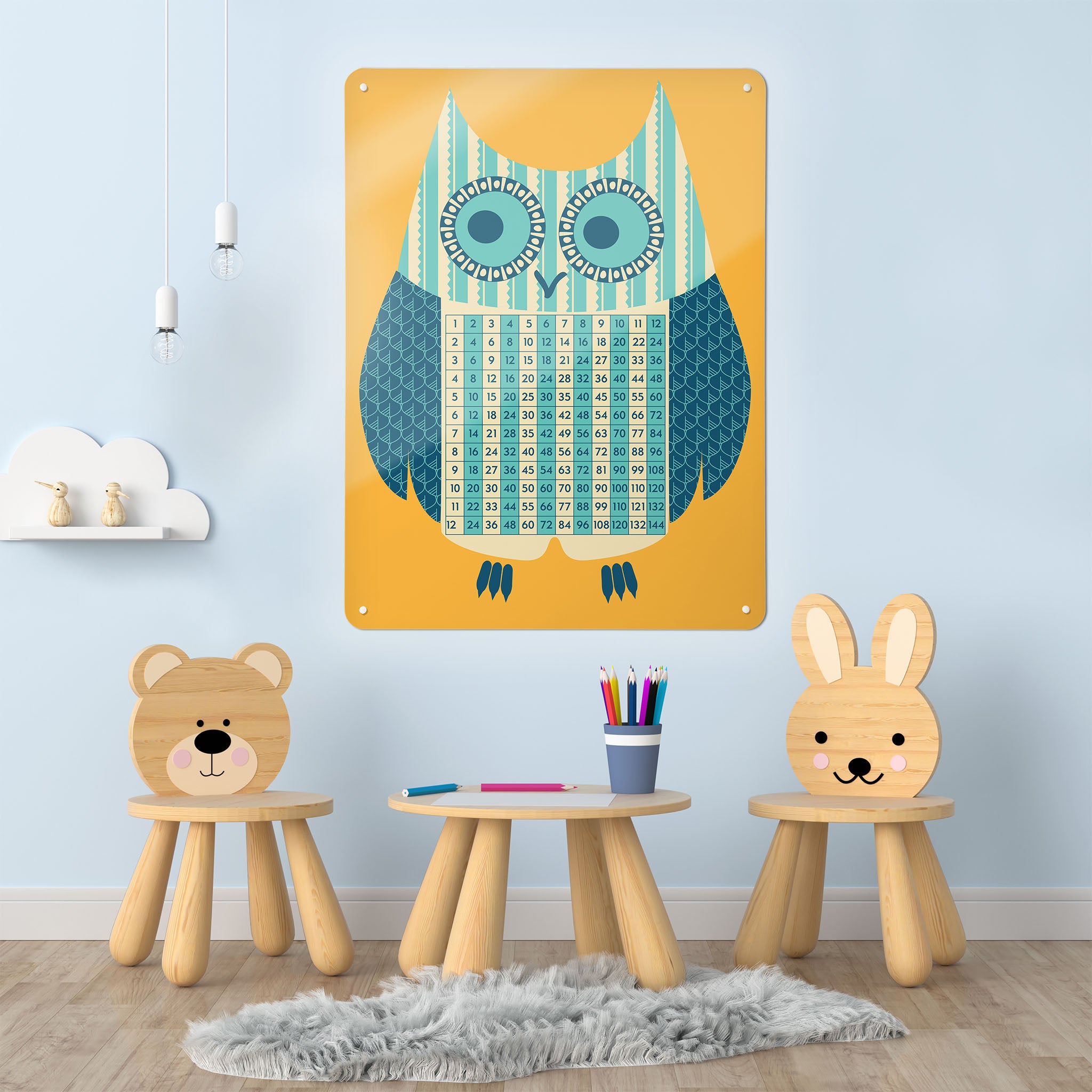 A playroom interior with a magnetic metal wall art panel showing an illustration of an owl with a times tables design in blue, cream, teal and orange