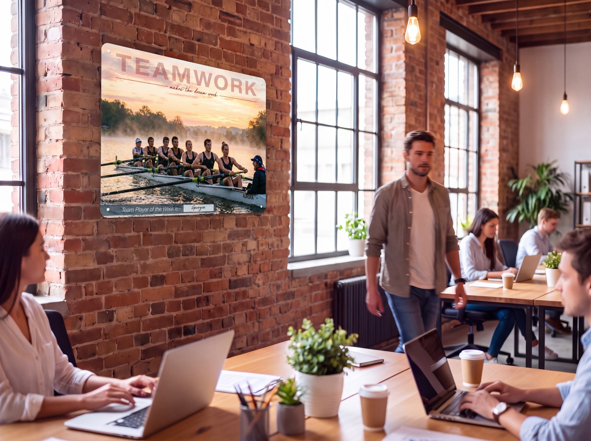 Teamwork panel on a brick office wall, staff working at desks