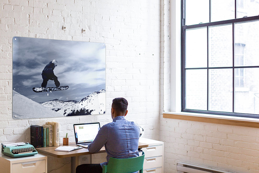 A Create Your Own board printed with a snowboarding photograph, hanging in an office
