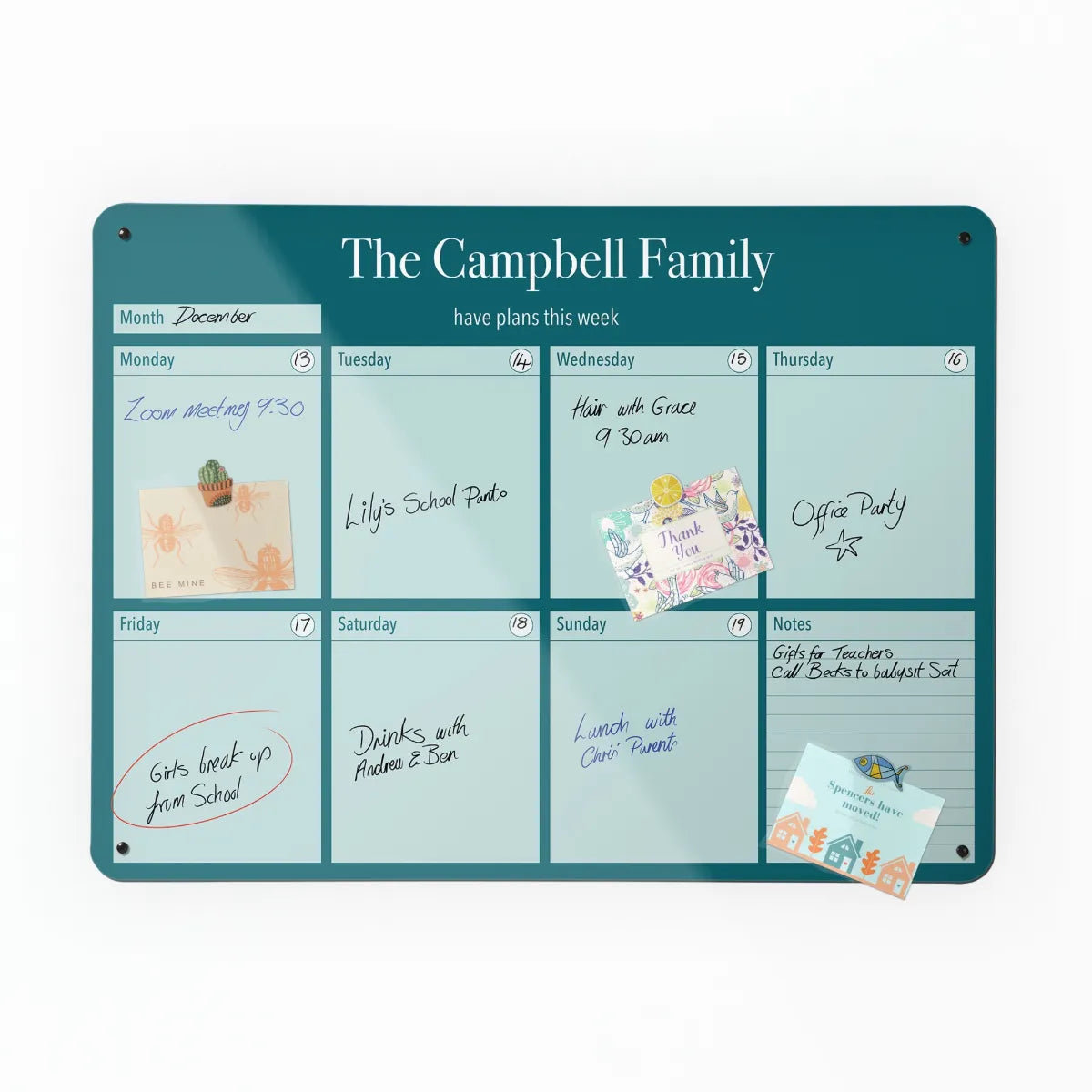 The Plain colour — Teal personalised weekly planner, filled in by hand with a postcard held on by a magnet